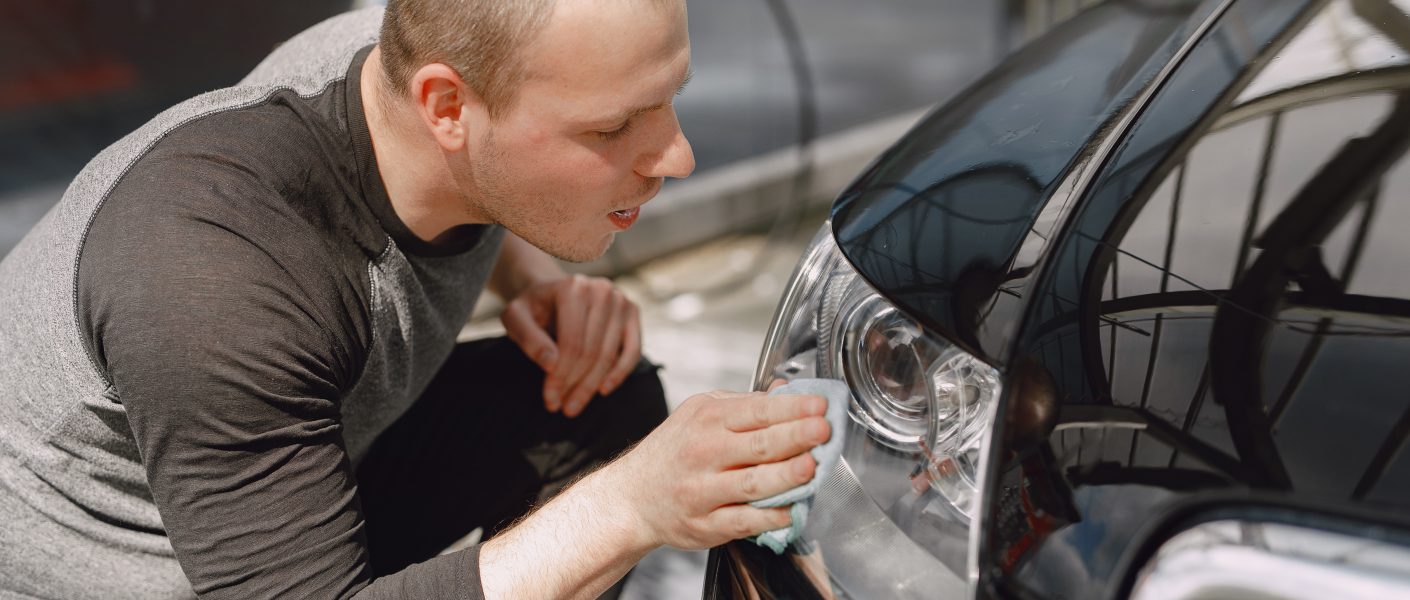 Mężczyzna starannie pielęgnujący auto – konserwacja pojazdów Gorlice w praktyce.