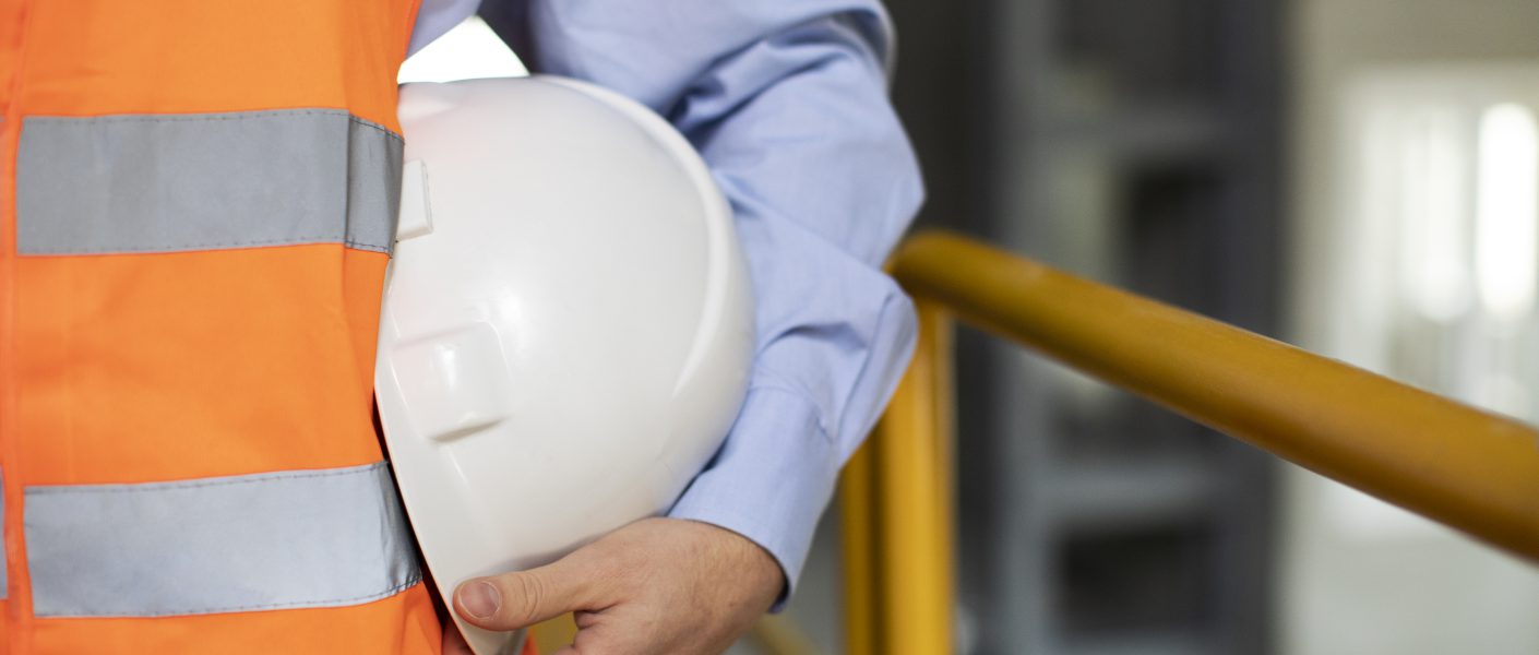 System kontroli produkcji kraków - budowlaniec stojący z kaskiem ochrionnym