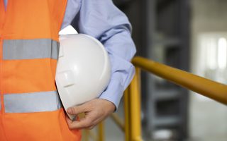 System kontroli produkcji kraków - budowlaniec stojący z kaskiem ochrionnym