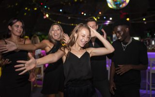 Dynamiczna scena w night clubie w Małopolsce, pełna tańczących ludzi i kolorowych świateł, idealne miejsce na nocną zabawę.