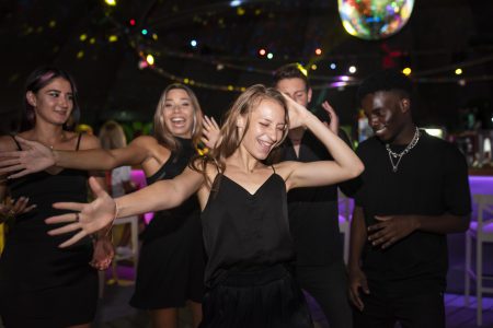 Dynamiczna scena w night clubie w Małopolsce, pełna tańczących ludzi i kolorowych świateł, idealne miejsce na nocną zabawę.