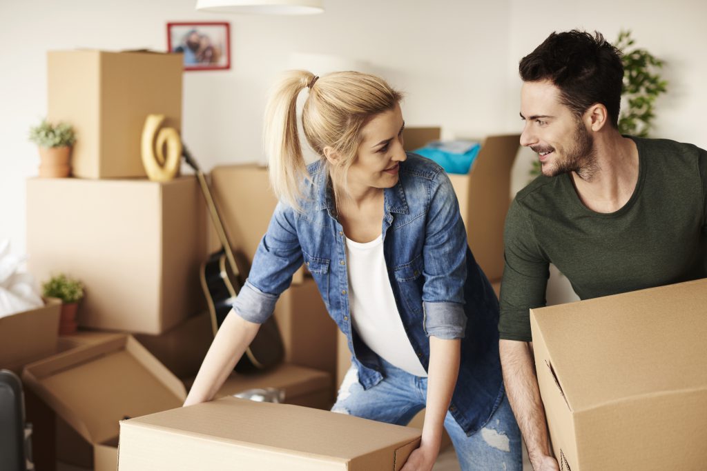 Młoda para rozpakowująca rzeczy po sprzedaży mieszkania – skup nieruchomości z lokatorami