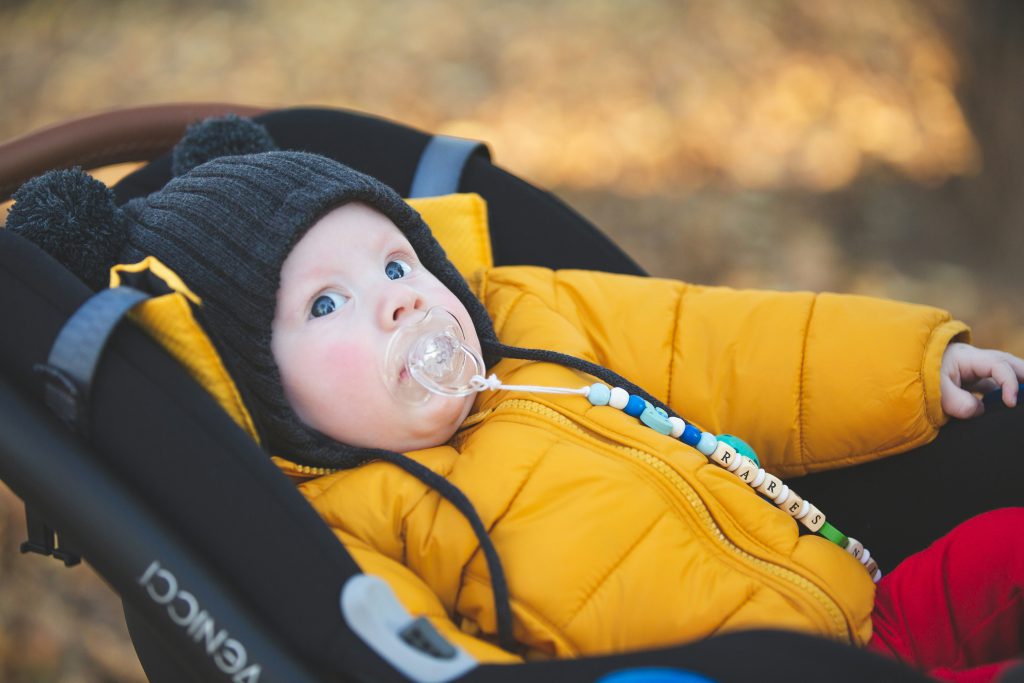 zdjęcie dziecka w żółtej kurtce w wózku