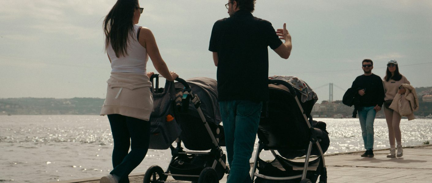 zdjęcie matki i ojca spacerujących z dziećmi w wózkach