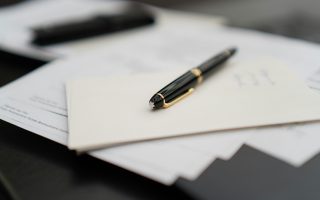 zdjęcie długopisu i papierów na stole