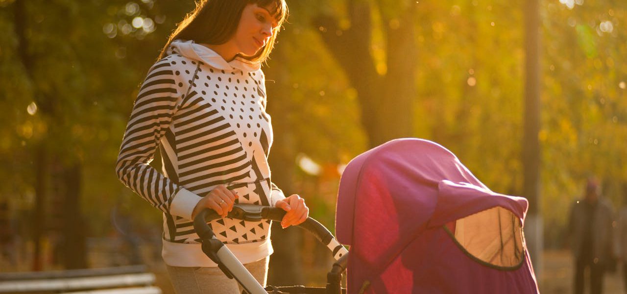matka w parku na spacerze z polskim wózkiem dziecięcym