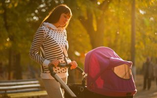 matka w parku na spacerze z polskim wózkiem dziecięcym