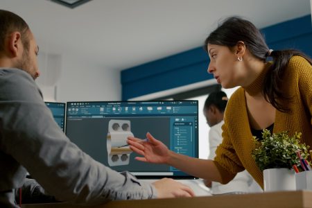 Inżynierowie omawiają projekt elementu konstrukcyjnego na ekranie komputera, modelowanie 3d w budownictwie w programie CAD