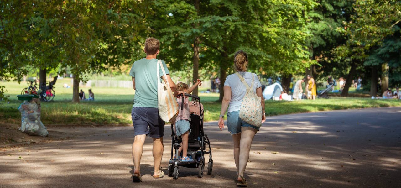 mama i tata spacerują po parku z wózkiem od polskiego producenta
