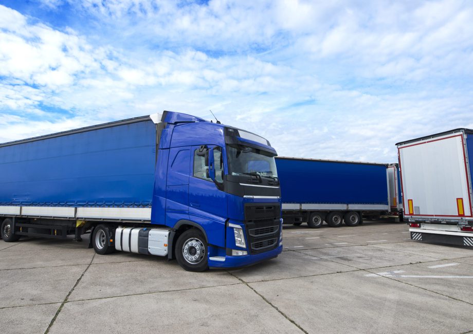 Niebieski tir z naczepą typu plandeka zaparkowany na placu manewrowym, stanowiący część floty realizującej transport farmaceutyczny w Bydgoszczy.