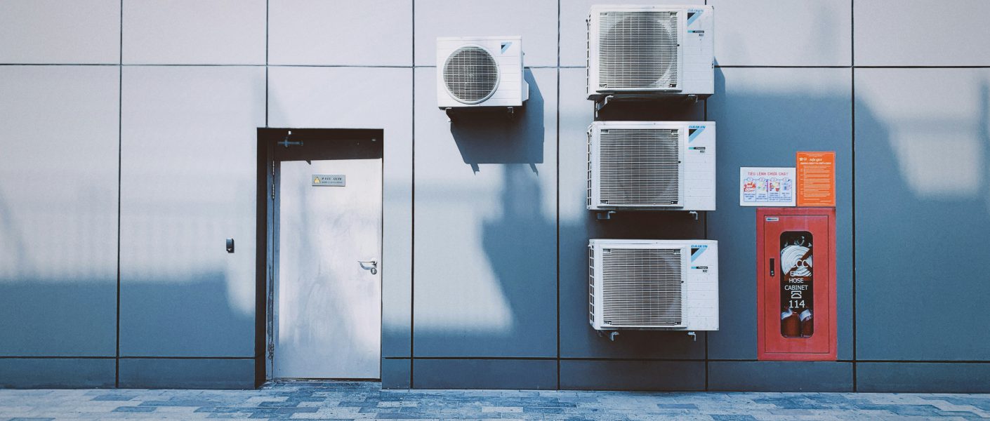 zdjęcie przedstawia fragment elewacji nowoczesnego budynku wykończonego dużymi, szarymi panelami.