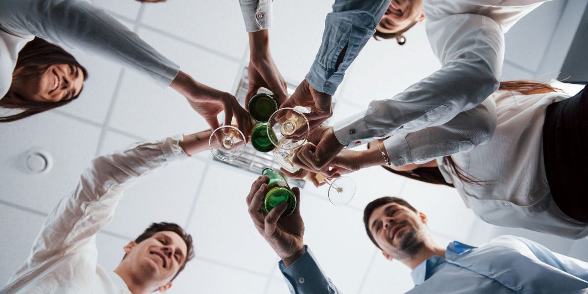 Grupa pracowników podnosi toast podczas imprezy firmowej w Katowicach.