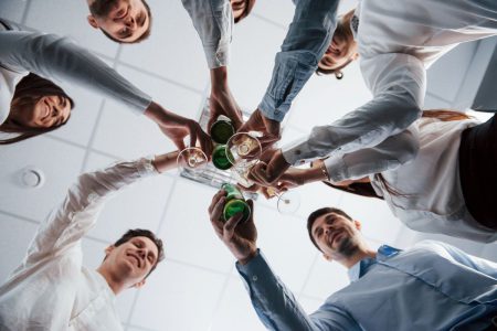 Grupa pracowników podnosi toast podczas imprezy firmowej w Katowicach.