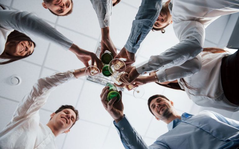 Grupa pracowników podnosi toast podczas imprezy firmowej w Katowicach.