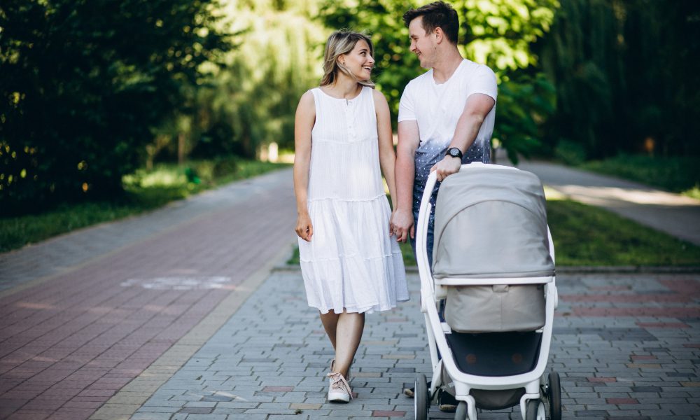 tata i mama podczas smaceru z dzieckiem w wózku nowoczesnym