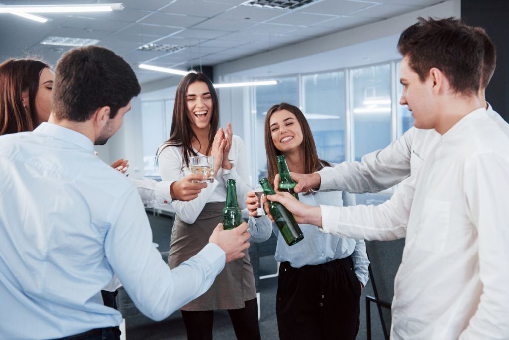 Grupa pracowników w biurze podnosi toast podczas imprezy firmowej w Katowicach.