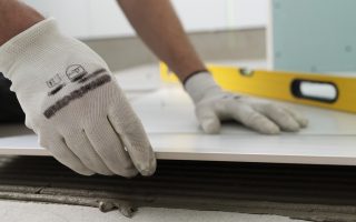 mężczyzna w ręakiwckach kładący płytki - remonty trójmiasto